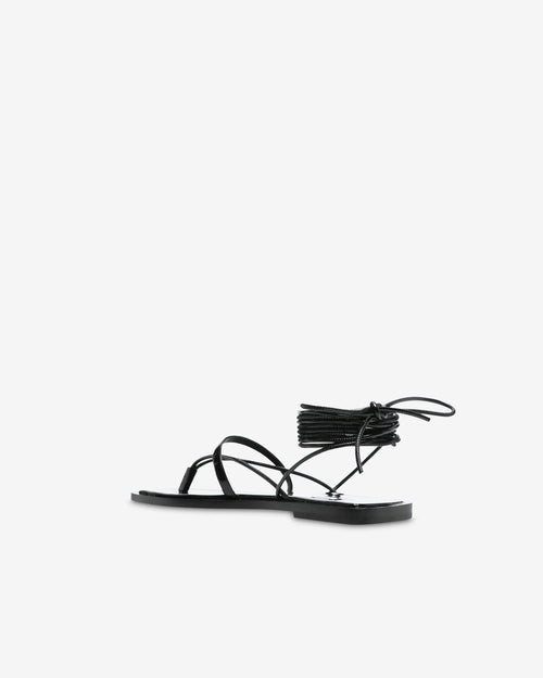 Black patent leather flat sandals with ankle straps